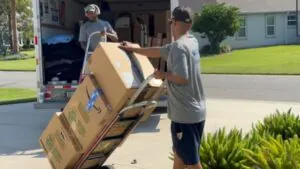 Mover using a dolly to transport a large box during a Florida move