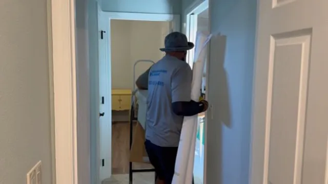 Mover carrying a long household item through a hallway during a Florida move