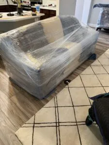 Wrapped couch prepared for residential moving by Village Movers and Storage in North Central Florida